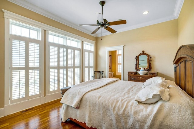 bedroom with ornamental molding, wood-type flooring, and ceiling fan