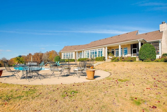 rear view of property featuring a patio area and a lawn