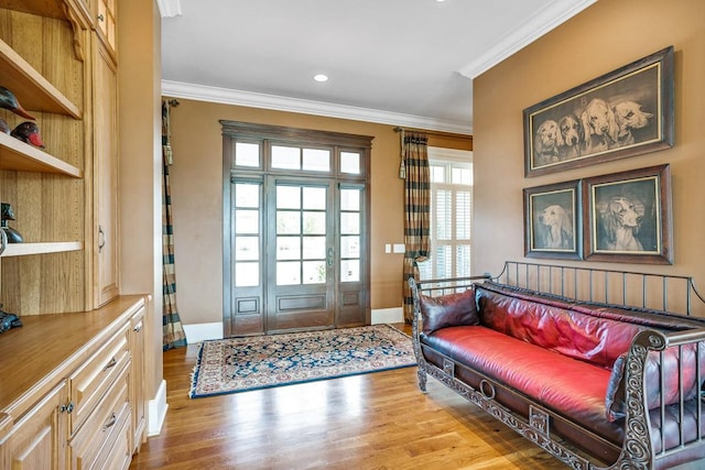 entrance foyer featuring ornamental molding and light hardwood / wood-style floors