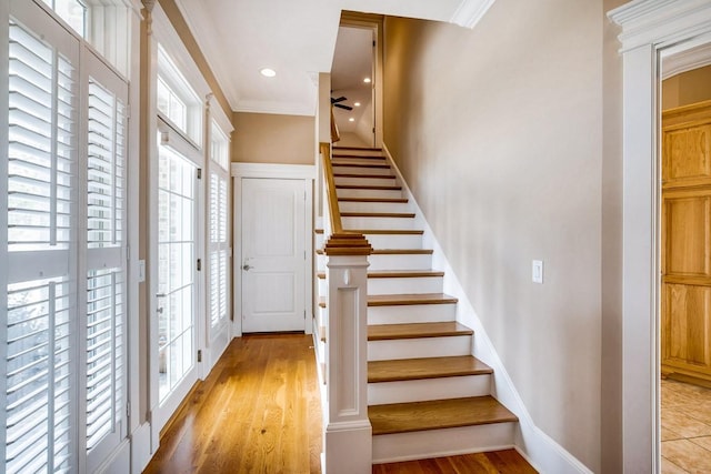 foyer entrance featuring crown molding and light wood-type flooring