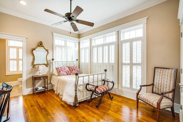 bedroom with ornamental molding, connected bathroom, wood-type flooring, and multiple windows