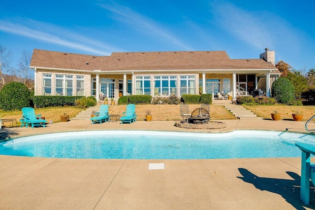 view of swimming pool featuring a patio and an outdoor fire pit