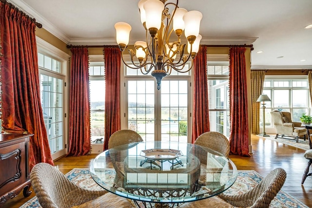 dining room with ornamental molding, light hardwood / wood-style flooring, and a notable chandelier