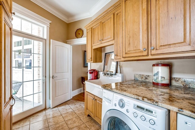 clothes washing area featuring washer / dryer, sink, crown molding, cabinets, and light tile patterned floors