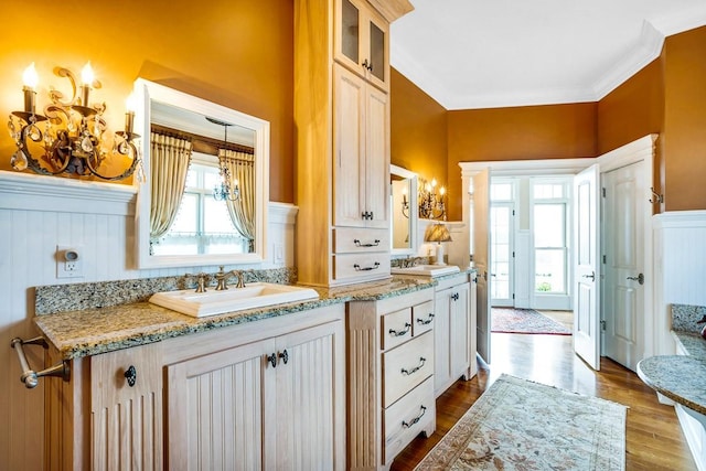 bathroom with hardwood / wood-style flooring, ornamental molding, and vanity