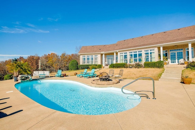 view of swimming pool featuring a patio area and a fire pit