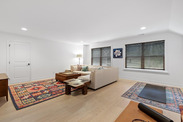 living room with vaulted ceiling and light wood-type flooring