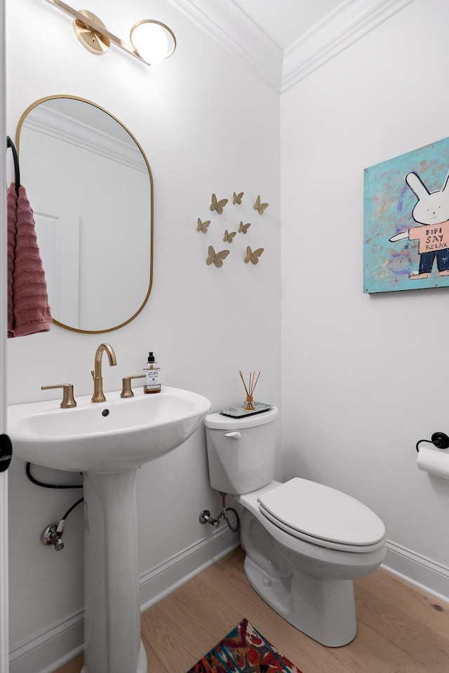 bathroom with ornamental molding, wood-type flooring, sink, and toilet