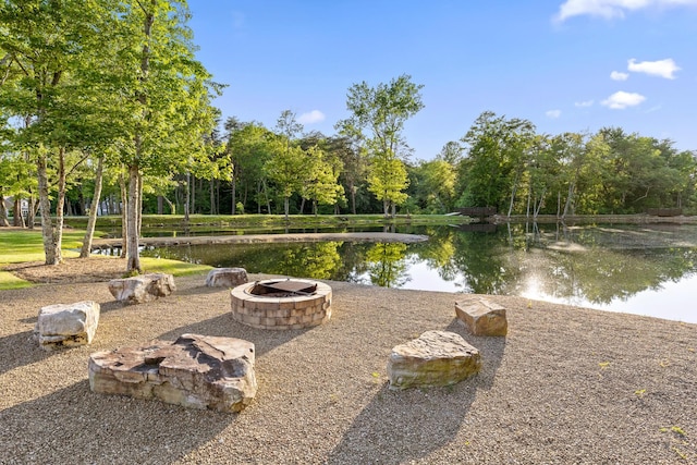 exterior space with a water view and an outdoor fire pit