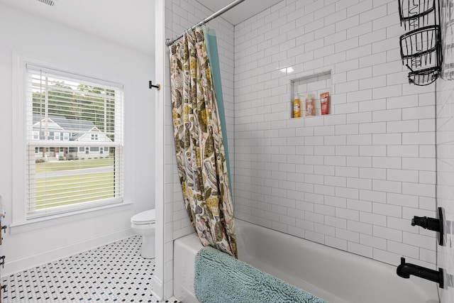 bathroom featuring shower / bath combination with curtain, tile patterned floors, and toilet