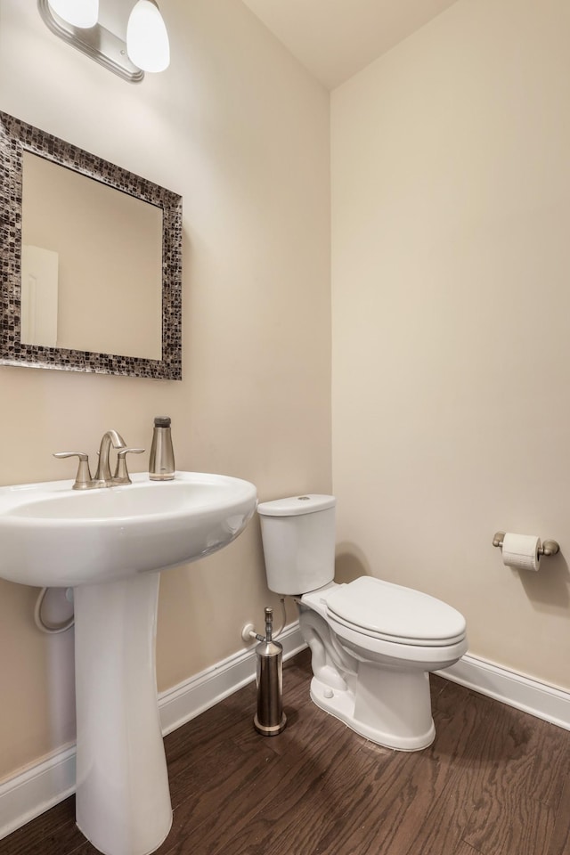 bathroom with sink, hardwood / wood-style floors, and toilet