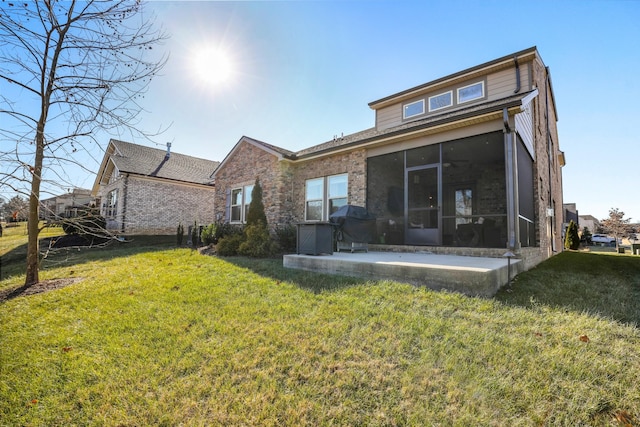 rear view of property featuring a patio, a sunroom, and a yard