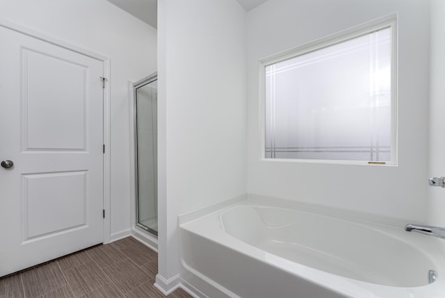 bathroom featuring shower with separate bathtub