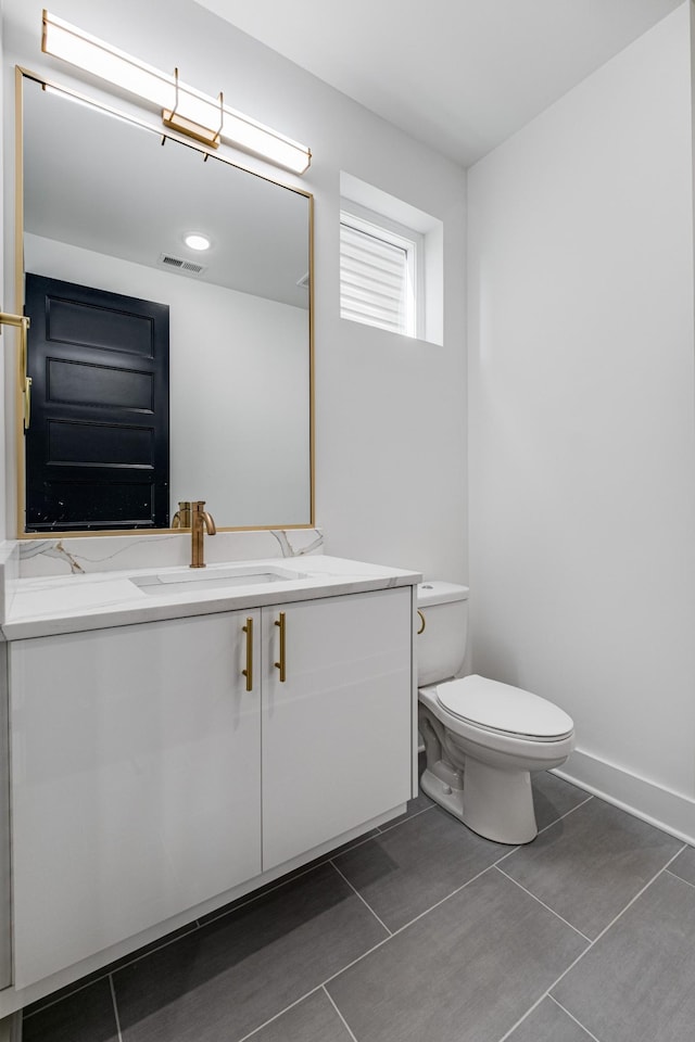 bathroom with vanity, toilet, and tile patterned flooring