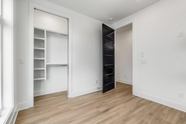 unfurnished bedroom featuring light hardwood / wood-style floors and a closet