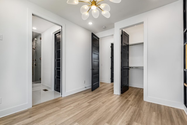 unfurnished bedroom featuring ensuite bath, light hardwood / wood-style floors, and a closet