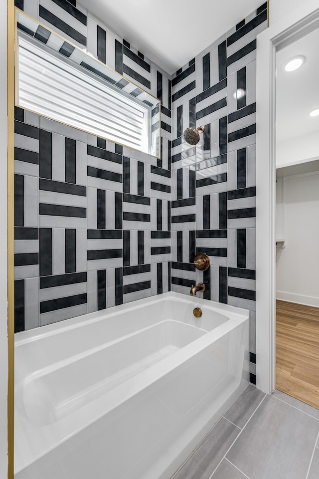 bathroom featuring tile patterned floors, plus walk in shower, and tile walls