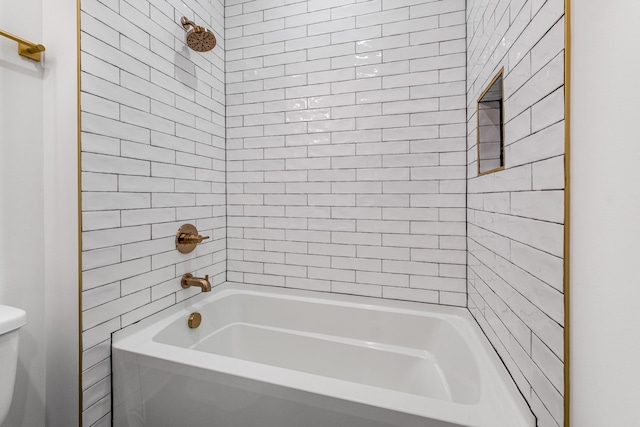 bathroom featuring tiled shower / bath and toilet