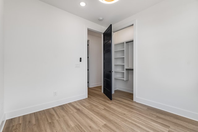 unfurnished bedroom with a closet and light wood-type flooring