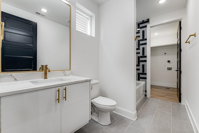 bathroom featuring vanity, tile patterned floors, and toilet