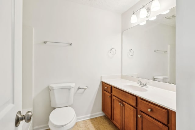 bathroom featuring a textured ceiling, toilet, visible vents, vanity, and baseboards