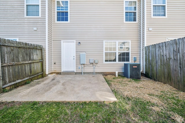 back of property with a patio area, central AC, and a fenced backyard