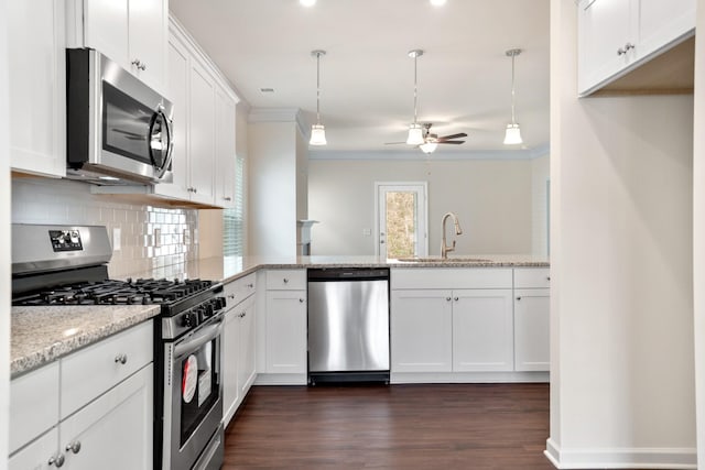 kitchen featuring white cabinetry, stainless steel appliances, light stone countertops, and hanging light fixtures