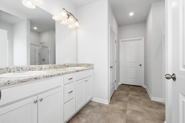 bathroom featuring a shower with door, vanity, and tile patterned flooring