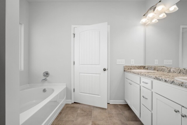 bathroom with tile patterned flooring, vanity, and a bathtub