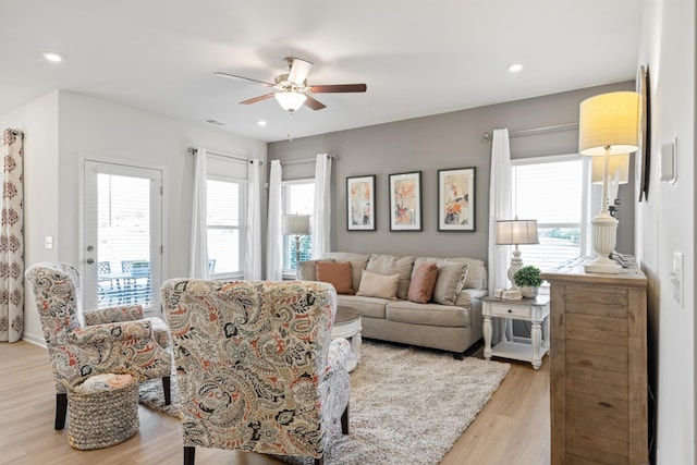 living room featuring light hardwood / wood-style flooring and ceiling fan