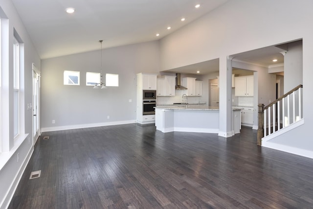 unfurnished living room with high vaulted ceiling, sink, a chandelier, and dark hardwood / wood-style flooring