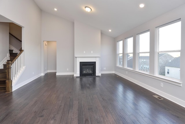 unfurnished living room with vaulted ceiling and dark hardwood / wood-style floors