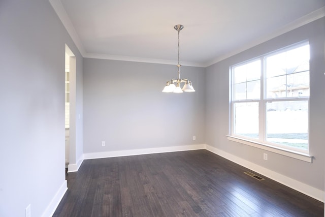 spare room featuring dark hardwood / wood-style flooring, ornamental molding, and an inviting chandelier