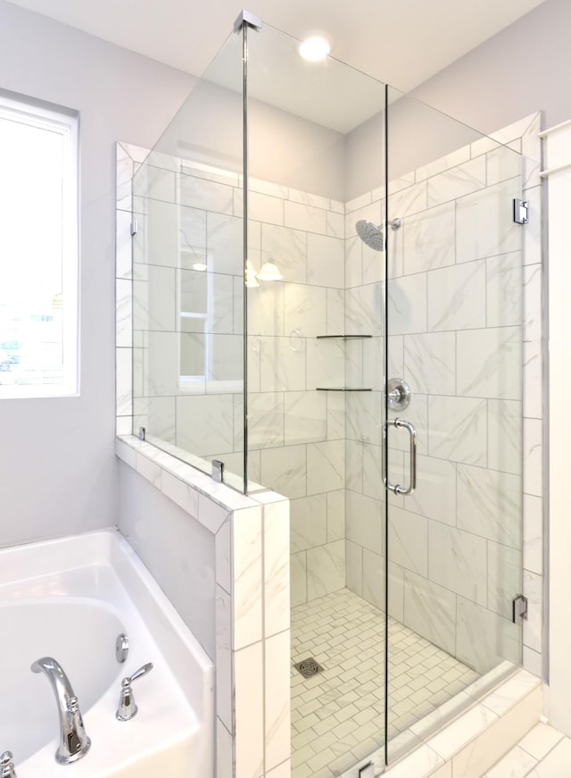 bathroom featuring shower with separate bathtub