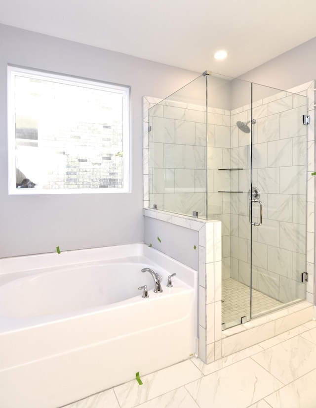 bathroom featuring shower with separate bathtub