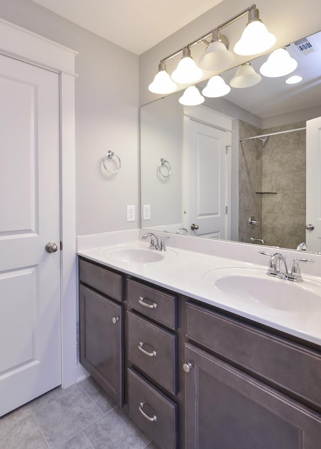 bathroom with tiled shower / bath combo, vanity, and tile patterned floors