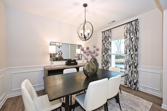 dining space with a notable chandelier and dark wood-type flooring