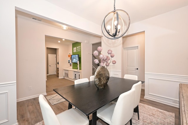 dining space featuring wood-type flooring and a chandelier