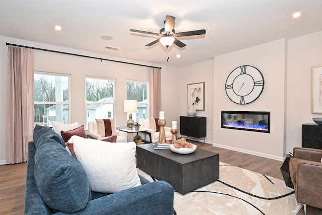 living room featuring hardwood / wood-style flooring, a healthy amount of sunlight, and ceiling fan