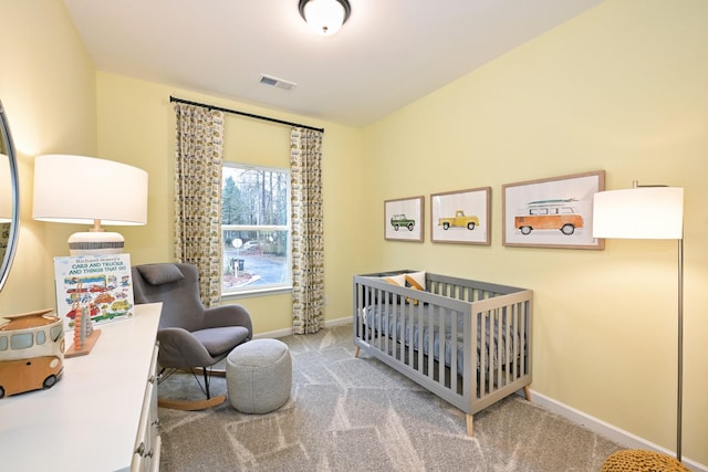 bedroom featuring a nursery area and light carpet