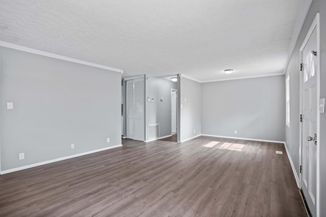 empty room featuring ornamental molding, dark hardwood / wood-style floors, and a textured ceiling