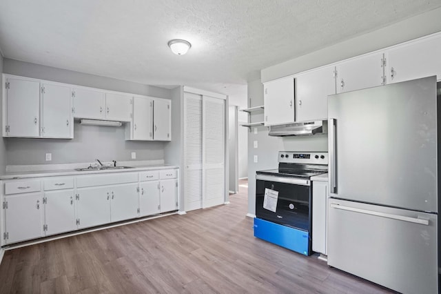 kitchen featuring appliances with stainless steel finishes, sink, white cabinets, and light wood-type flooring