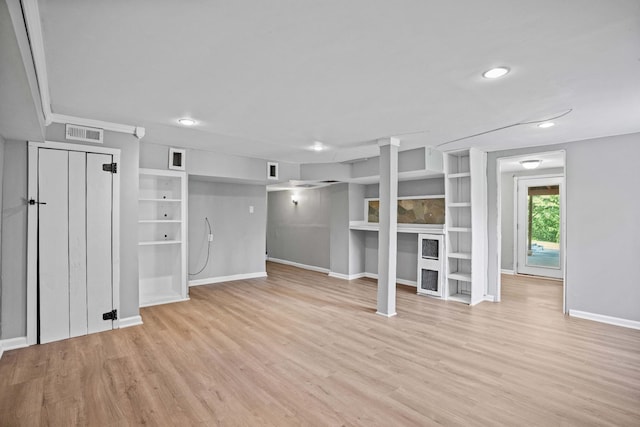 basement with built in shelves and light wood-type flooring