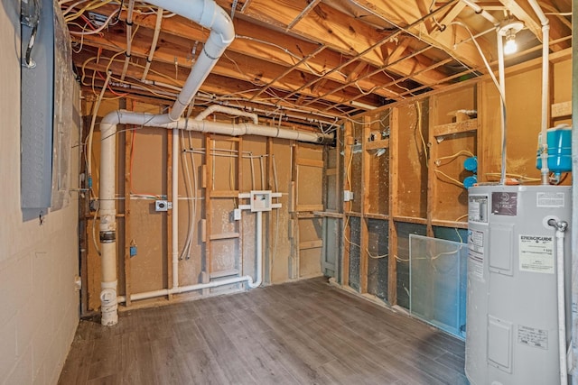 basement featuring water heater and dark hardwood / wood-style flooring