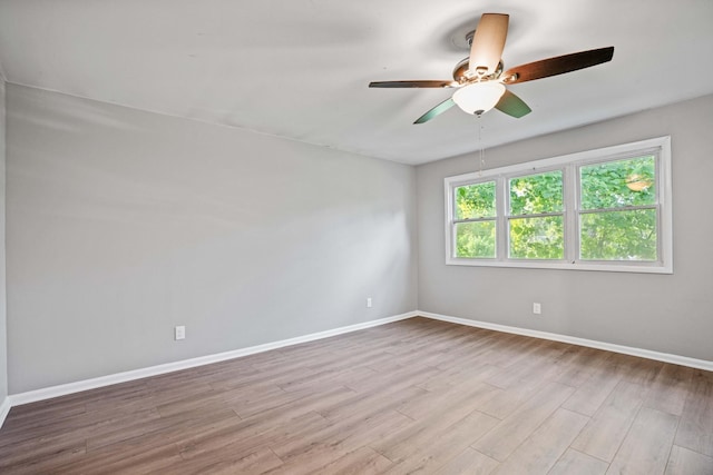 spare room with ceiling fan and light wood-type flooring