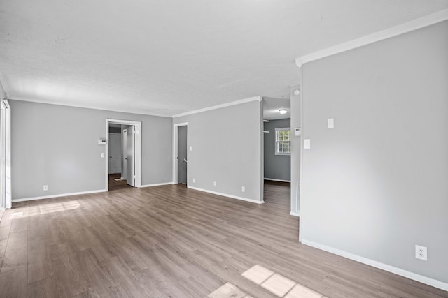 empty room featuring crown molding and light wood-type flooring