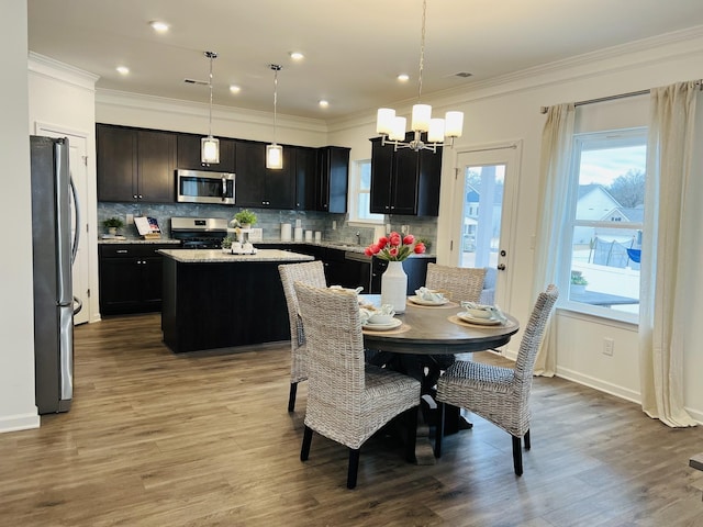 dining room with crown molding, light hardwood / wood-style flooring, and a notable chandelier