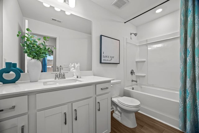 full bathroom with hardwood / wood-style flooring, vanity, shower / bath combo with shower curtain, and toilet