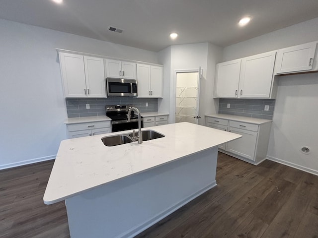 kitchen with sink, a center island with sink, dark hardwood / wood-style flooring, stainless steel appliances, and white cabinets