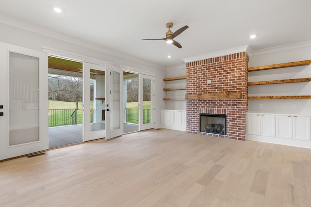 unfurnished living room with crown molding, ceiling fan, a fireplace, and light wood-type flooring